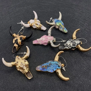 Detailed overhead view of multiple bull skull pendants in various acrylic stone textures