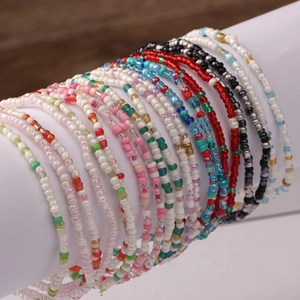 Handmade colorful seed bead bracelets set in various vibrant colors on a wooden display