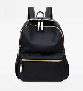 Detailed front view of black nylon backpack featuring premium golden zippers and pockets