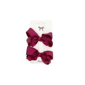 Set of two 3-inch burgundy ribbed ribbon bow hair clips on white card packaging