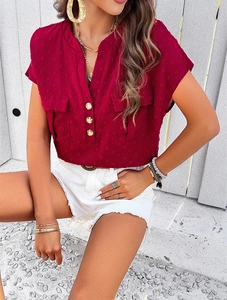 Detail view of wine red V-neck blouse with dot texture fabric and golden buttons