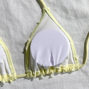 Dettaglio del top bikini in spugna gialla con tasca per imbottitura rimovibile