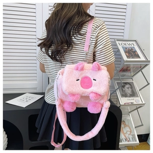 Pink plush cartoon beaver backpack with silver chain strap shown in a lifestyle setting