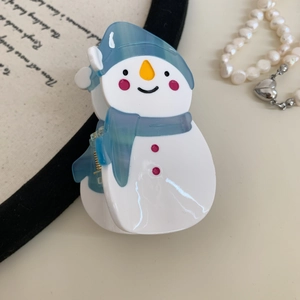 Détail d'une pince à cheveux en forme de bonhomme de neige avec écharpe bleue