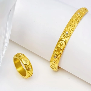 Close-up of gold celestial jewelry set with sun moon motifs and small crystals