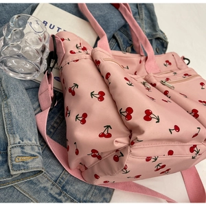 Detail of pink cherry print tote bag featuring zipper pocket and adjustable strap