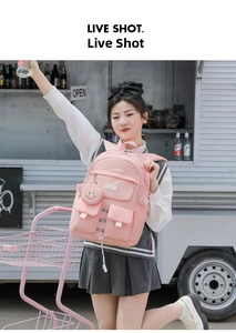 Outdoor shot of pink large capacity student backpack with a smiley pendant and drawstring