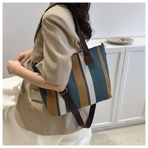 Vertical striped canvas tote bag in green, yellow, and white with adjustable brown strap