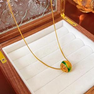 Dettaglio della collana con ciondolo rotondo traforato placcato oro 18K in scatola di legno