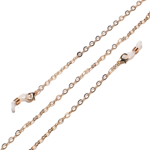 Detail of golden metal glasses chain featuring lobster clasps and silicone connectors