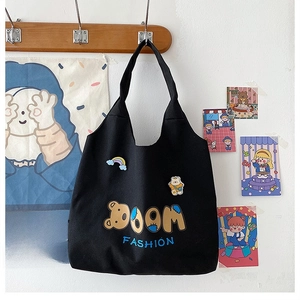 Detail der schwarzen Canvas-Tasche mit Boom Fashion-Druck und Bären-Stickerei
