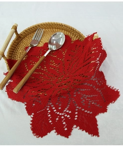 Close-up of red lace knitted round placemat with intricate star pattern on a tray