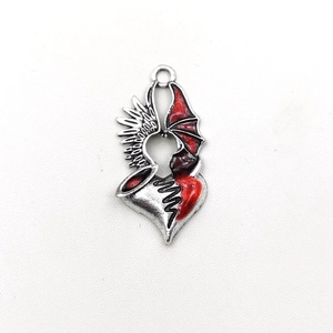 Detailed view of gothic heart wing pendant with red enamel and silver metallic finish