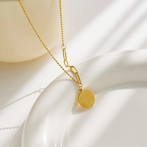 Détail du collier en acier doré avec pendentif Good Luck et maillons de chaîne à billes