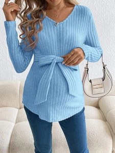 Detail of light blue ribbed knit maternity top with waist bow tie on a model