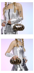 Close-up of leopard print hard shell clutch bag with gold chain strap held by a model