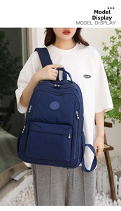 Outdoor model display of a deep blue waterproof nylon backpack with multiple compartments