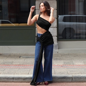 Détail du haut noir asymétrique ajouré avec lien à la taille et style urbain moderne