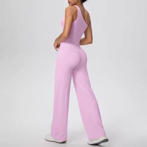 Détail d'un ensemble de yoga rose avec haut à une épaule et pantalon large taille haute