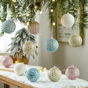 Blue and pink Christmas ball ornaments with glitter and textures on snowy pine branches