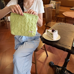 Close-up of light green quilted bubble fabric storage bag with colorful brand label