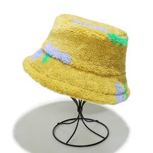 Dettaglio del cappello alla pescara in pile giallo con motivi astratti blu e verdi