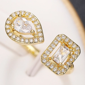 Macro shot of gold-plated open ring with teardrop and square cubic zirconia stones