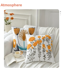 Detail of white cotton linen cushion covers with intricate yellow floral embroidery