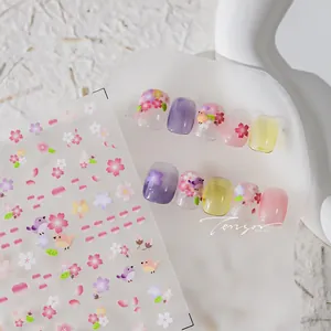Detail of floral nail art stickers with cherry blossoms and birds on purple gradient nails