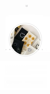 Close-up of cotton mid-calf socks with yellow smiley face embroidery and smile text