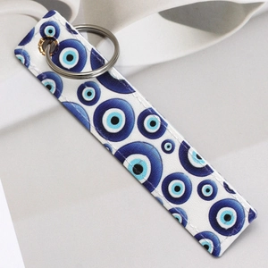 Detailed view of evil eye faux leather keychain with silver metal ring and stitch