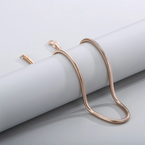 Close-up of rose gold stainless steel snake chain wrapped around a cylindrical display stand