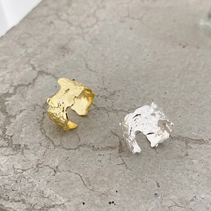 Macro shot of S925 sterling silver rings with irregular lava texture on natural stone