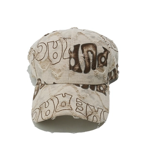 Close-up of distressed vintage baseball cap with embroidered letters and torn details