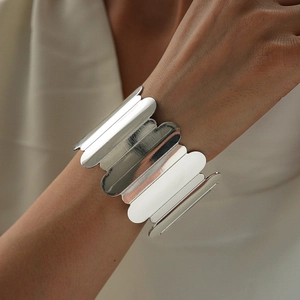 Macro shot of a chunky silver geometric cuff bracelet with a polished mirror finish