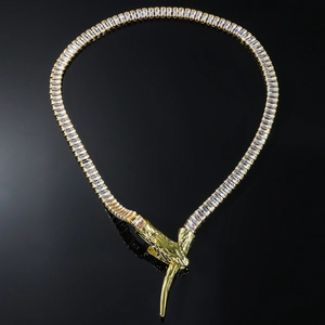 Detail of gold snake chain with clear stones and unique hand-shaped clasp on black background