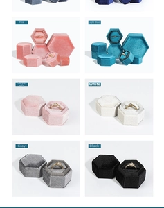 Various colors of hexagonal velvet jewelry boxes including pink, blue, white, and gray