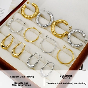 Detailed view of polished gold and silver hoop earrings inside a velvet jewelry box