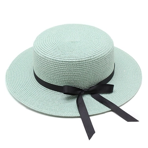 Élégant chapeau de paille canotier vert menthe avec ruban noir sur fond blanc