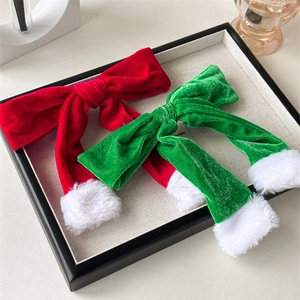 Detail of red and green velvet Christmas bow hair clips with white faux fur trim