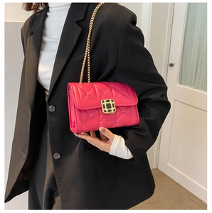 Close-up of bright pink quilted crossbody bag with gold chain strap and square metal buckle