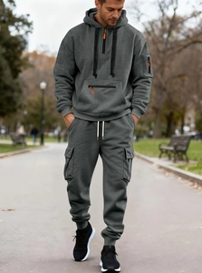 Detail of dark gray men's tracksuit featuring half-zip hoodie and multi-pocket cargo pants