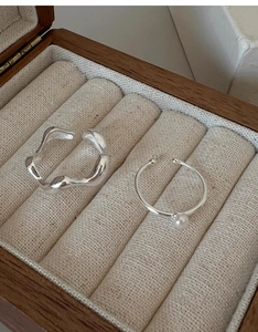 Detail of s925 silver wave band and freshwater pearl ring in a velvet jewelry box