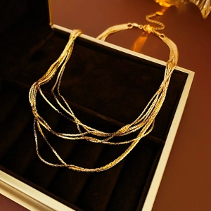 Close-up of layered gold snake chain necklace in a black velvet jewelry box