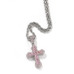Macro shot of hip hop cross pendant with pink square-cut zircon and silver twist rope chain