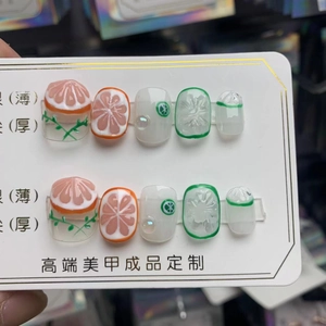 Détail d'ongles faits main sur le thème des fruits avec motifs 3D d'orange et de citron