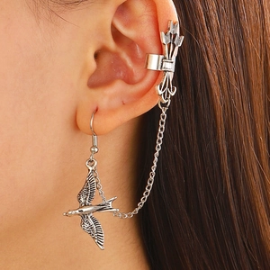 Macro shot of silver hummingbird stud and arrow ear cuff with elegant chain fringe