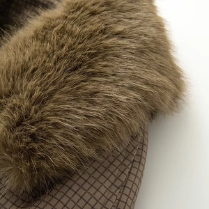 Detail of faux fur collar and brown checkered lining on reversible trench coat
