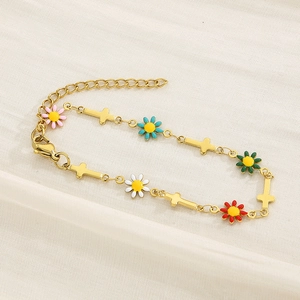 Detail of gold chain bracelet featuring colorful enamel flowers and a cross charm