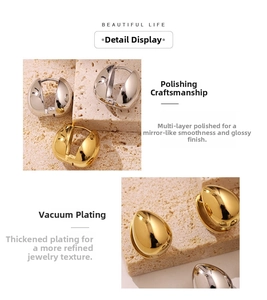 Macro detail of polished gold and silver water drop earrings on a stone background